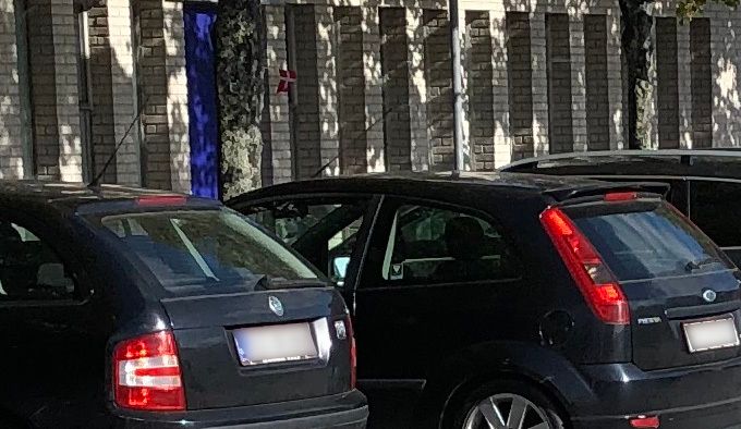 Foto: Lars Laursen - en parkeringsvagt benytter sin mobiltelefon til at at tage fotos af de parkerede biler ved Seniorklubberne.
